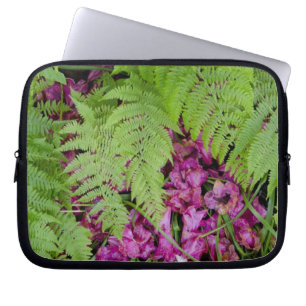 Waldfarne mit rosa Blütenblättern auf dem Boden Laptopschutzhülle
