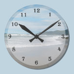 Wall Clock am Strand Runde Wanduhr<br><div class="desc">Suchen Sie eine Wand zum Thema Strand? Dieses Uhrendesign ist vielleicht genau das,  was Sie suchen,  da es eine Szene am Strand mit den Wellen an einem Sandstrand und den Bergen in der Ferne bietet. Eine schöne Möglichkeit,  Ihrem Zuhause ein Strandthema hinzuzufügen. Copyright Kathy Henis</div>