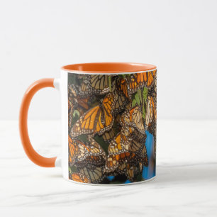 Wanderfalter-Monarchschmetterlinge klammern sich a Tasse