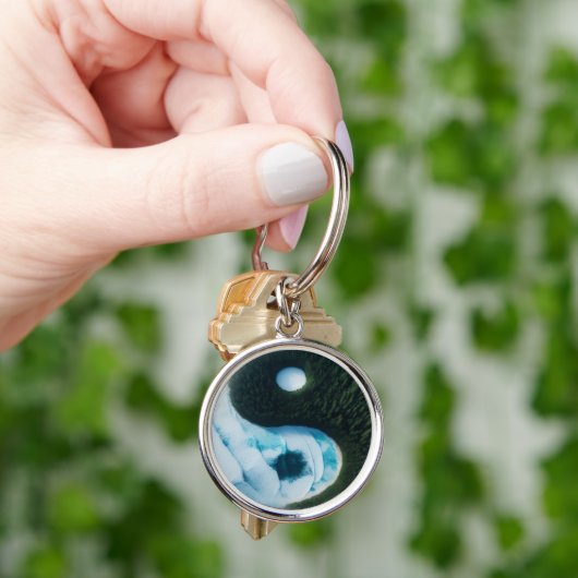 Wasser und Schlüsselanhänger auf der Erde (Hand)