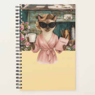 Weibliche Katze hält Terminkalender Planer