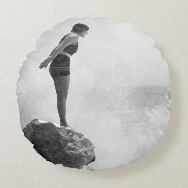 Weibliche Schwimmerin auf Felsen über dem abstürze Rundes Kissen (Vorderseite)