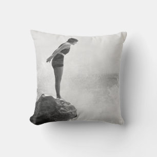 Weibliche Schwimmerin auf Felsen über tosenden Wel Kissen