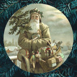 Weihnachten, Viktorianischer Weihnachtsmann mit Sp Runder Aufkleber<br><div class="desc">Vintage Illustration Weihnachtsfeierdesign mit einem Viktorianischen Weihnachtsmann,  der durch den Schnee verlassend Fußspuren geht. Er trägt einen Weihnachtsbaum und einen Körbchen Spielzeug auf einem bewölkten Abend,  wobei der Mond durch die Wolken strahlt. Ursprünglich eine skandinavische Postkarte mit dem Text: Gott Jul oder Frohe Weihnachten.</div>