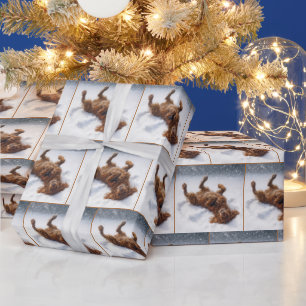 Weihnachts-Irish-Setter macht einen Schneengel Geschenkpapier