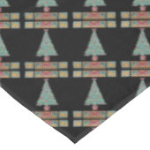 Weihnachtsbaum mit Dekorationsrot beugt Tischdecke (Schrägansicht)