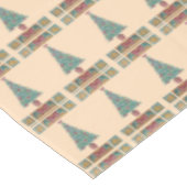 Weihnachtsbaum mit Dekorationsrot beugt Tischdecke (Schrägansicht)