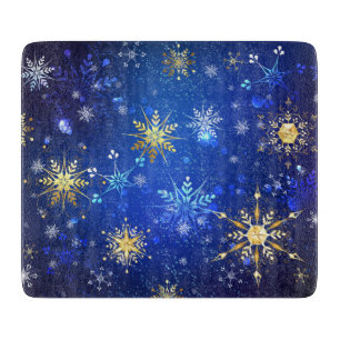 Weihnachtsblauer Hintergrund mit goldenen Schneefl Schneidebrett