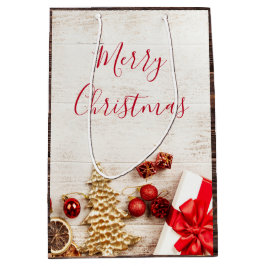 Weihnachtsgeschenkartikel auf einem rustikalen Hol Mittlere Geschenktüte