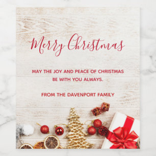 Weihnachtsgeschenkartikel auf einem rustikalen Hol Weinetikett