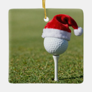 Weihnachtsgolfball mit Santa-Hut auf Tee auf Grün Keramikornament