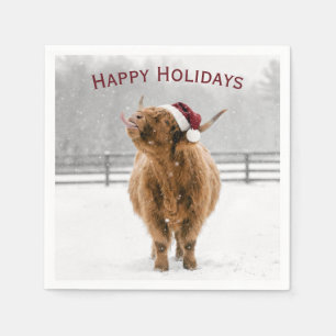Weihnachtshochlandkuh leckt Schneeflocken Serviette