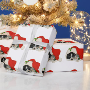 Weihnachtshund und Katze in einer Weihnachtsmannmü Geschenkpapier