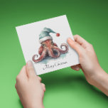 Weihnachtsoctopus Feiertagskarte<br><div class="desc">Aquarellmalerei mit einem niedlich rosa Oktopus,  der einen türkisfarbenen Winterhut im Weihnachtsstil trägt</div>