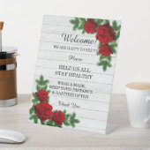 Weihnachtssicherheitsmaßnahmen für rote Rosen und Sockelschild (In SItu)