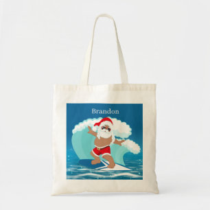 Weihnachtsstrand Der Weihnachtsmann gibt den Kinde Tragetasche