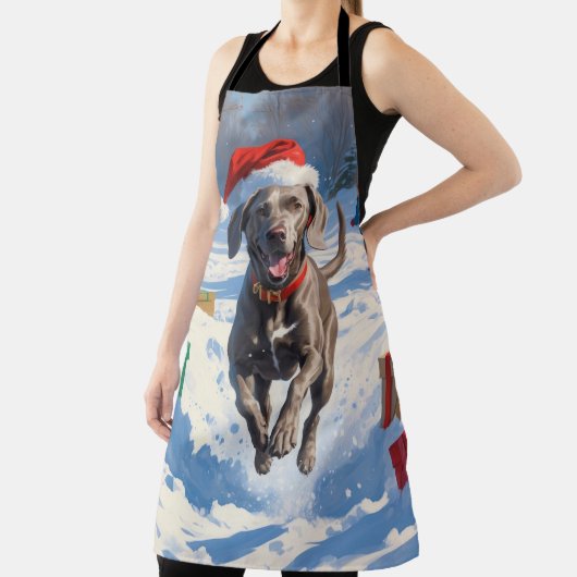 Weimaraner läuft im Schnee mit Weihnachtshut Schürze (InSitu)