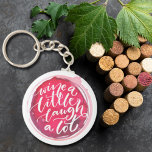 Wein ein wenig lachen Eine Menge Schlüsselanhänger<br><div class="desc">Auf einem Rotweinfleck steht der Schlüsselanhänger "Wine a Little Lagh A Lot". Schlüsselanhänger machen unvergessliche Geschenke für Familie und Freunde oder kreieren für sich selbst.</div>
