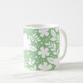Weiße Blumengestaltung auf weichem grünem Hintergr Kaffeetasse