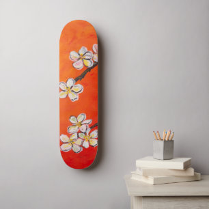 Weiße Blüten auf orangefarbenem Federhintergrund Skateboard