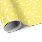 Weiße Confetti-Sprinklen auf hellgelben Geschenkpapier (Rolleneckpunkt)