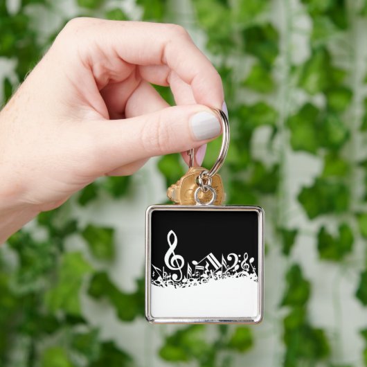 Weiße durcheinandergebrachte musikalische schlüsselanhänger (Hand)