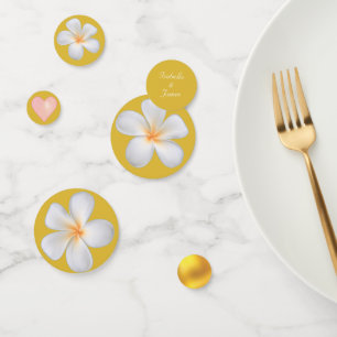 Weiße Frangipani-Plumerienblüten auf goldenem Konfetti