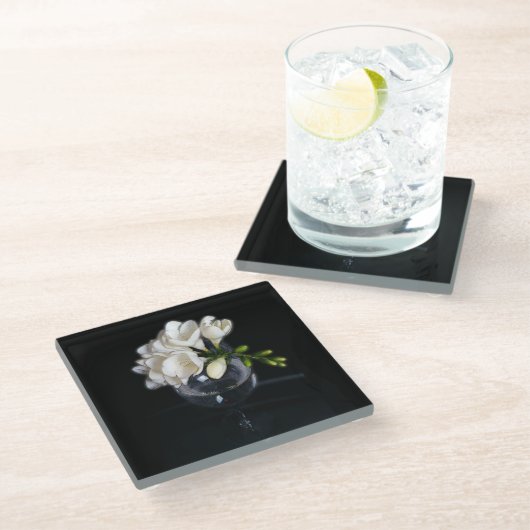 weiße Freesie in einem Glas Glasuntersetzer (Schrägansicht)