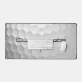 Weiße golfkugel mit strukturierter oberfläche und  schreibtischunterlage (Tastatur & Maus)