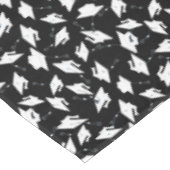 Weiße Graduierungskappen in die Luft geworfen auf Tischdecke (Schrägansicht)