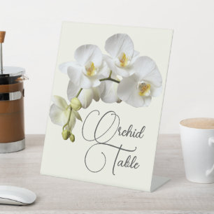 Weiße Orchideen, die den Namen oder die Nummer ein Sockelschild