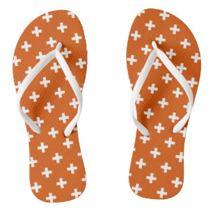 Weiße Polka-Kreuze auf verbrannter Orange Badesandalen