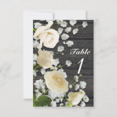 Weiße Rosen und Gipskraut auf Tischnummer aus Holz (Rückseite)