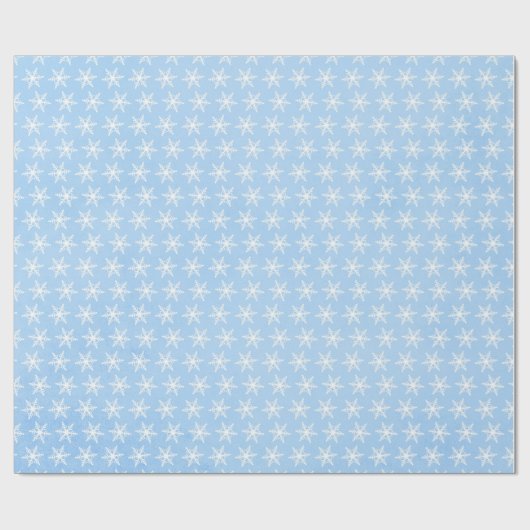 Weiße Schneeflocken auf blass blau Geschenkpapier (Flach)