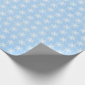 Weiße Schneeflocken auf blass blau Geschenkpapier (Ecke)