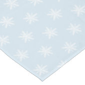 Weiße Schneeflocken auf blauer Tischdecke (Schrägansicht)