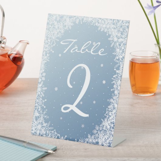 Weiße Schneeflocken auf blauer Tischnummer Sockelschild (In Situ)