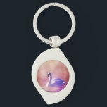 Weiße Schwäne, die auf einem scheußlichen See schw Schlüsselanhänger<br><div class="desc">Ein charmantes,  skurriles Märchenbild. Weich romantisches Foto eines weißen Schwans in lila Licht,  das auf einem scheußlichen See schwimmt. Farbenfrohe Purples und Pinks schaffen eine mystische magische Stimmung.</div>