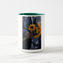 Weiße Tasse, auf der eine Hand Sonnenblumen mit AJ