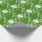 Weiße tropische Blume und Blätter auf grün Geschenkpapier (Ecke)