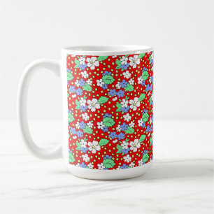 Weiße und blaue Blumen auf roter Kaffeetasse