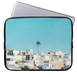 Weiße und braune Betonhäuser unter blauem Himmel i Laptopschutzhülle