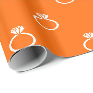 Weiße Verlobungsringe auf Orange Geschenkpapier