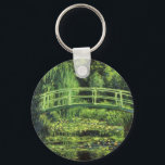 Weiße Wasserlilien von Claude Monet, Vintage Kunst Schlüsselanhänger<br><div class="desc">Die weißen Wasserlilien (1899) von Claude Monet sind ein Vintager Impressionist, der sich mit einem Blumengemälde auskennt. Es ist eine von vielen Variationen der Wasserlilien und japanischen Fußgängergemälde, die Monet in seinem Blumengarten im Frühjahr in Giverny, Frankreich, gemalt hat. Eine Fußgängerbrücke über einen Teich in grünen Tönen. Über den Künstler:...</div>