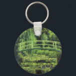 Weiße Wasserlilien von Claude Monet, Vintage Kunst Schlüsselanhänger<br><div class="desc">Die weißen Wasserlilien (1899) von Claude Monet sind ein Vintager Impressionist, der sich mit einem Blumengemälde auskennt. Es ist eine von vielen Variationen der Wasserlilien und japanischen Fußgängergemälde, die Monet in seinem Blumengarten im Frühjahr in Giverny, Frankreich, gemalt hat. Eine Fußgängerbrücke über einen Teich in grünen Tönen. Über den Künstler:...</div>