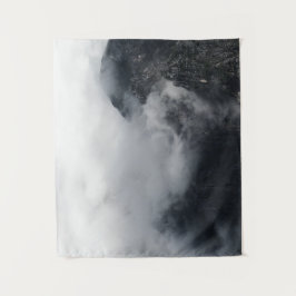 Weiße Wolken über den dunklen felsigen Bergen Wandteppich