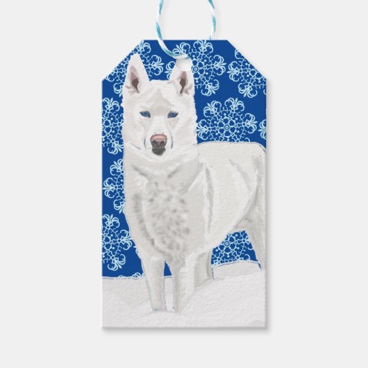 Weißer Husky gegen Schneeflocken und dunkelblauer Geschenkanhänger (Vorderseite)