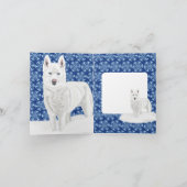 Weißer Husky gegen Schneeflocken und dunkelblauer Karte (Innenseite)