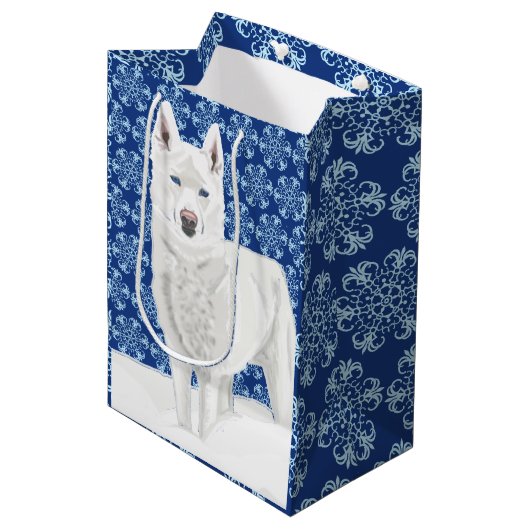 Weißer Husky gegen Schneeflocken und dunkelblauer Mittlere Geschenktüte (Vorderseite Schrägansicht)