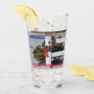 Weißer Zaun mit Schnee und ein roter Bow-Glas-Cup Glas